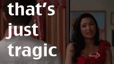 A Woman In A Red Dress Is Standing Next To A Man In A White Shirt And Looking At Him . GIF