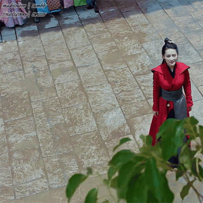 A Woman In A Red Dress Is Standing On A Brick Walkway With A Watermark That Says Madebylove Tumblr GIF