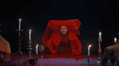 A Woman In A Red Dress Is Surrounded By Lit Candles And Says I Warned You GIF