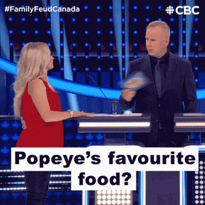 A Woman In A Red Dress Is Talking To A Man In A Suit On A Television Show Called Family Feud Canada GIF