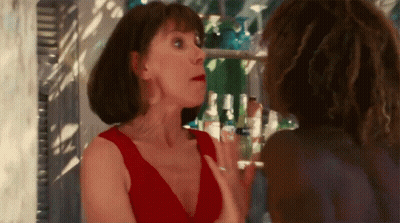 A Woman In A Red Dress Is Talking To Another Woman In A Bar GIF