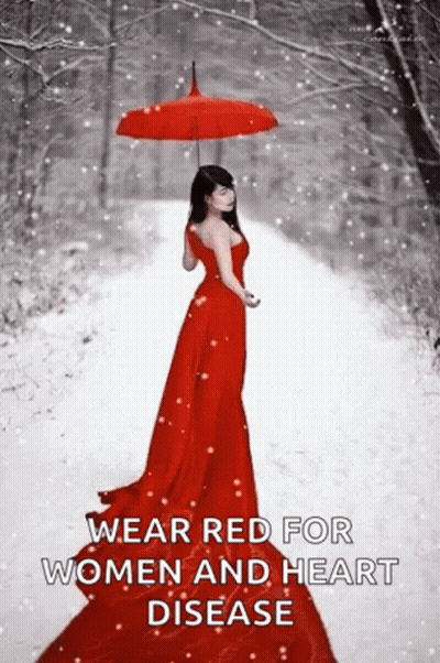 A Woman In A Red Dress Is Walking In The Snow With An Umbrella . GIF