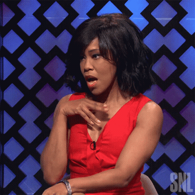 A Woman In A Red Dress Sitting In Front Of A Snl Sign GIF