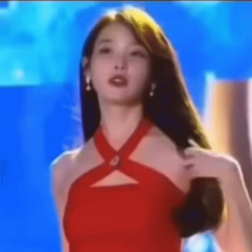 A Woman In A Red Dress Stands In Front Of A Blue Background . GIF