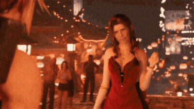A Woman In A Red Dress Stands In Front Of A Crowd Of People GIF