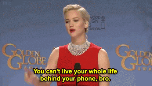 A Woman In A Red Dress Stands In Front Of A Microphone And Says You Can 'T Live Your Whole Life Behind Your Phone GIF