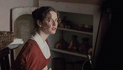 A Woman In A Red Dress Stands In Front Of A Shelf GIF