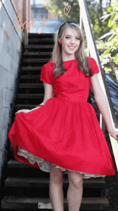 A Woman In A Red Dress Stands On A Set Of Stairs With The Words " I Love You " Written On The Bottom GIF