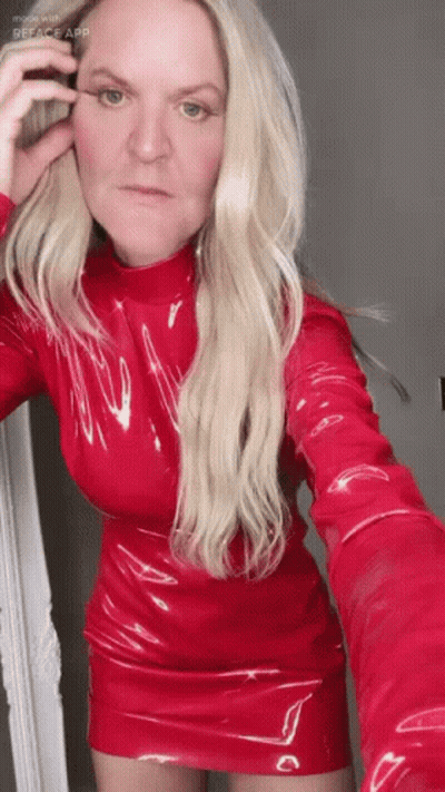 A Woman In A Red Dress Taking A Selfie With Reface App GIF