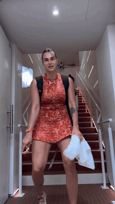 A Woman In A Red Dress Walking Down Stairs GIF