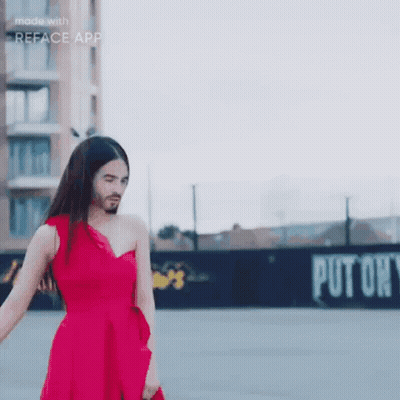 A Woman In A Red Dress With A Beard Is Standing In Front Of A Sign That Says Put On GIF