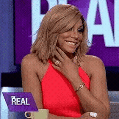 A Woman In A Red Dress With A Purple Sign That Says Real GIF