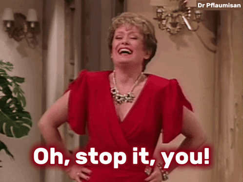 A Woman In A Red Dress With Her Hands On Her Hips Says Oh Stop It You GIF