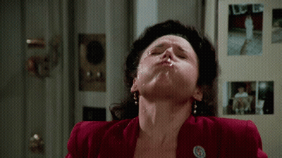 A Woman In A Red Jacket Has A Badge On Her Jacket That Says ' A ' On It GIF