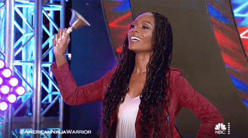 A Woman In A Red Jacket Holds A Bell In Her Hand GIF