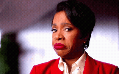 A Woman In A Red Jacket Is Making A Face GIF