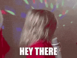 A Woman In A Red Jacket Is Singing Into A Microphone With The Words Hey There Above Her Head . GIF