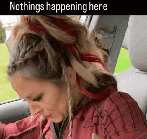 A Woman In A Red Jacket Is Sitting In The Back Seat Of A Car With A Caption That Says Nothings Happening Here GIF
