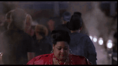 A Woman In A Red Jacket Is Standing In Front Of A Neon Sign That Says ' A ' On It GIF