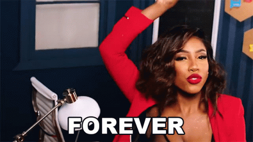 A Woman In A Red Jacket Is Standing In Front Of A Sign That Says Forever GIF