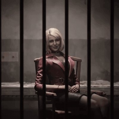 A Woman In A Red Jacket Sits In A Jail Cell GIF