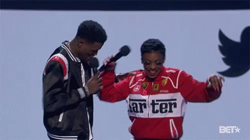 A Woman In A Red Jacket That Says " Carter " Is Dancing With A Man Holding A Microphone GIF