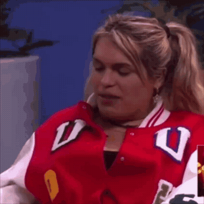 A Woman In A Red Jacket With The Letter U On It GIF