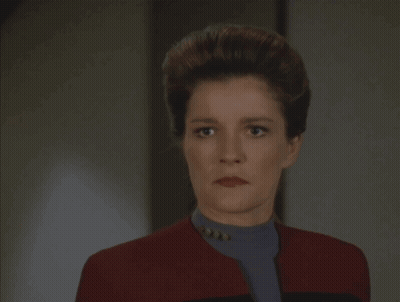 A Woman In A Red Jacket With The Word Coward Written On It GIF