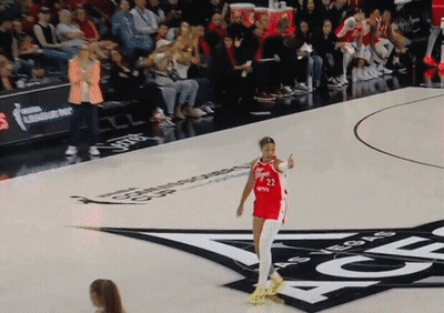 A Woman In A Red Jersey With The Number 22 On It Stands On A Basketball Court GIF