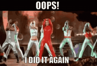 A Woman In A Red Jumpsuit Stands In Front Of A Group Of Dancers With The Caption Oops I Did It Again GIF