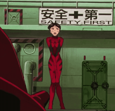 A Woman In A Red Jumpsuit Stands In Front Of A Sign That Says Safety First GIF