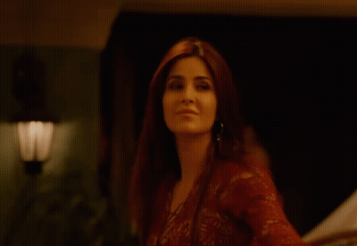 A Woman In A Red Lace Top Is Smiling GIF