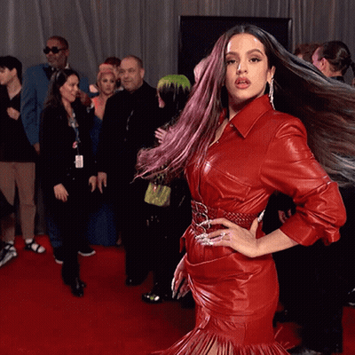 A Woman In A Red Leather Dress Is Posing For A Picture GIF