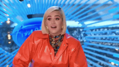 A Woman In A Red Leather Jacket Is Standing In Front Of A Blue Background And Smiling . GIF