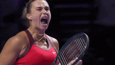 A Woman In A Red Nike Shirt Is Holding A Tennis Racket GIF