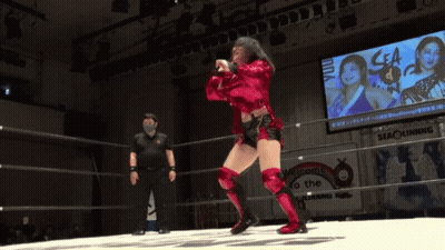 A Woman In A Red Outfit Is Dancing In A Wrestling Ring GIF