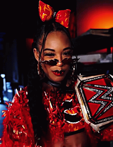 A Woman In A Red Outfit Is Holding A Wrestling Trophy GIF
