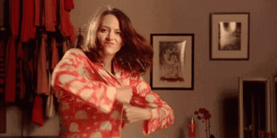 A Woman In A Red Pajamas Is Dancing In A Room GIF
