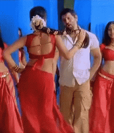 A Woman In A Red Saree Is Dancing With A Man GIF