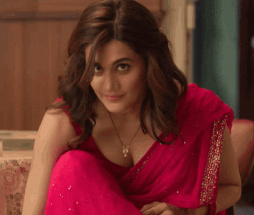 A Woman In A Red Saree Is Sitting On A Chair GIF