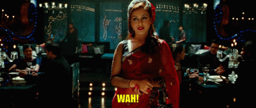 A Woman In A Red Sari Is Standing In A Room And Says Wah GIF