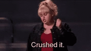 A Woman In A Red Shirt And Black Jacket Is Standing On A Stage And Says `` Crushed It . '' GIF