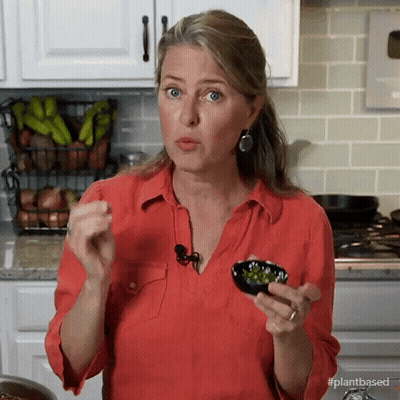 A Woman In A Red Shirt Is Holding A Bowl Of Vegetables In Her Hands GIF