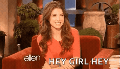 A Woman In A Red Shirt Is Sitting In A Chair And Smiling While Talking To Ellen Degeneres . GIF