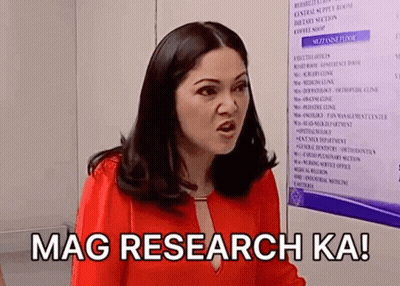 A Woman In A Red Shirt Is Standing In Front Of A Sign That Says Mag Research Ka ! GIF