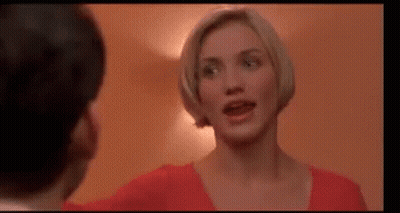 A Woman In A Red Shirt Is Standing Next To A Man In A Room . GIF