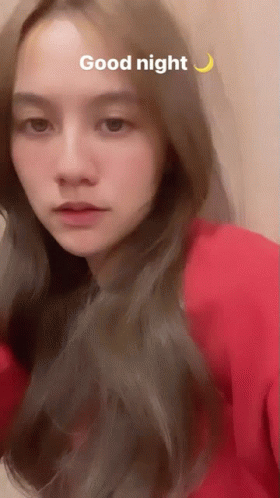 A Woman In A Red Shirt Says Good Night With A Crescent Moon Behind Her GIF