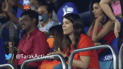 A Woman In A Red Shirt Sits In A Stadium With A Twitter / @Tarakactivist Written Below Her GIF