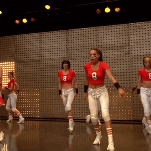 A Woman In A Red Shirt With The Number 8 On It Is Dancing GIF