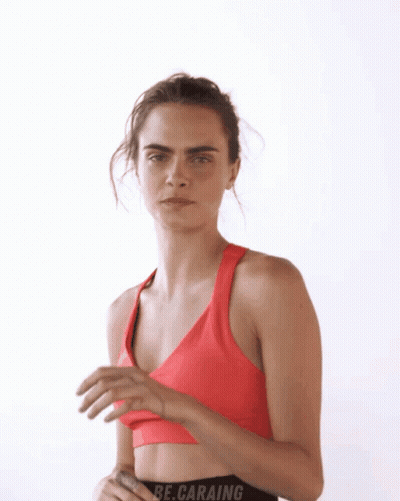 A Woman In A Red Sports Bra With The Word Be.caraing On The Bottom GIF